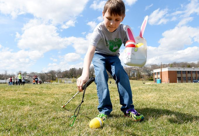 Child with cane searches for easter egg